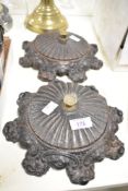 A pair of 19th century cast iron lidded items raised on scroll rosette feet, w22cm