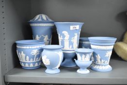 Eight pieces of Wedgwood blue and white Jasperware, to include a dancing hours lidded vase, an urn