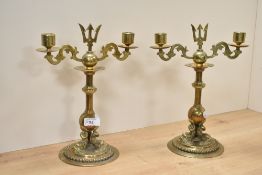 A pair of brass turned candlesticks with trident top and a trio sea sepent base, h27.5cm