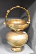 An early 20th century Indian Kamandalu brass holy water carrier having loop handle, engraved with