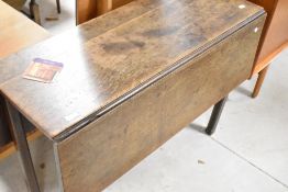 An early 19th Century dining table having narrow top and square gate legs, width approx. 97cm , open
