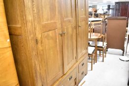 A modern oak triple wardrobe having multi drawer base, width approx. 160cm, height 195cm, depth