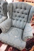 A pair of traditional wingback armchairs , having button backs
