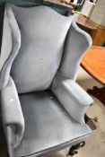 An early 20th Century wing back armchair in blue dralon , having knurl legs