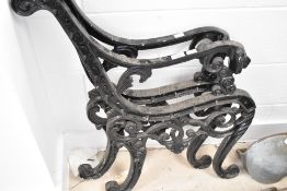 A pair of cast bench ends having lion mask arms
