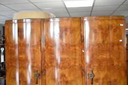 An Art Deco walnut wardrobe, having triple shaped doors, with partially fitted interior, width