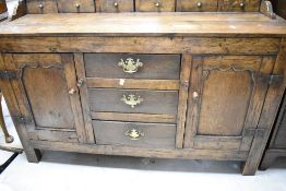 A period oak dresser having open delft rack back, with three central drawers to base, flanked by