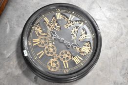 A modern battery powered wall clock, of circular form, with faux exposed workings, diameter