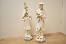 Two oriental cast composition figures depicting a male holding a scroll and a female holding a