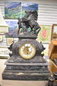 An antique French style spelter horse black marble effect clock (has sustained some damage to base)