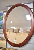 A modern oval mirror in dark colour frame