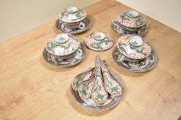 A group of four Chinese porcelain lidded soup bowls, along with five spoons, having decorative green