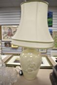 A large ceramic table lamp of baluster form, decorated with floral patterns on a green glaze ground,