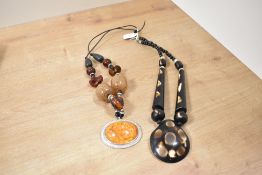 Two large beaded statement necklaces, one of carved wood and the other of glass and faux amber