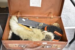 An early 20th century brown card suit case containing various brush heads, measuring tools, desk