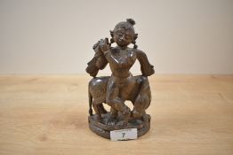 A hand carved Buddhist sculpture of cow and figure playing the flute, h15cm Condition report: