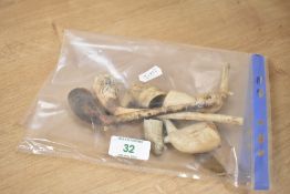 A small selection of clay pipes and pipe bowls and a cased set of dessert spoons