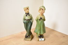 A pair of vintage chalk ware figures of Dutch boy and girl, wearing green garments, h25cm