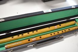 A cased pair of Chinese bamboo flutes, text translates as Suzhou National Musical Instrument