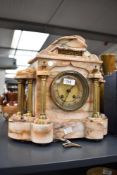 A victorian 8-day varigated marble mantel clock having brass dial flanked either side with Doric
