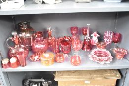 A quantity of cranberry glassware, to include a bell, vase, decanter and a turned wooden trinket