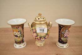 A Royal Crown Derby bone china urn with cover, having shaped handle and floral relief decoration,