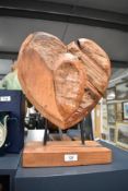 A carved wooden heart shaped sculpture supported on mental pins, h42cm