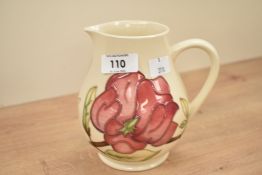A Moorcroft pottery 'Magnolia' pattern pottery jug, tublined with floral decoration and raised on