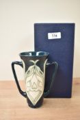 A Moorcroft pottery 'Snowdrop' pattern vase having tube lined decoration, twin shaped handles and