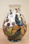A Moorcroft pottery vase of lobed form, tube lined with floral and foliage decoration, painted and