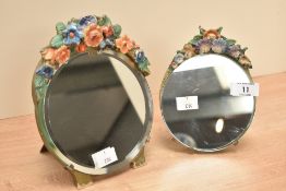 Two circular Barbela dressing table mirrors decorated with flowers and having easel back, largest