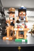 A vintage toymaker/potmaker nutcracker, h39cm, sold together with a similar stylenutcracker, (2)