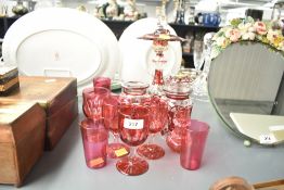 A small vintage cranberry glass pitcher of lobed form having clear shaped handle, h12cm, sold