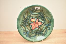 A Moorcroft Pottery Rainforest pattern plate, tube-lined with stylised foliage against a green