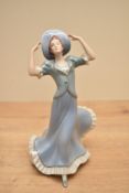An Art Deco style Czechoslovakian Royal Dux porcelain figurien of a female wearing blue dress and
