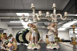 A pair of 19th century porcelain 4 branch candlabras depicting male and female figures with money