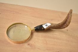 A 20th century magnifying glass having horn handle, glass width 9cm x handle length 12cm x overall