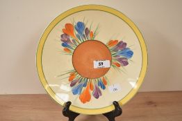 An early 20th century Clarice Cliff 'Bizarre' pattern circular plate, decorated with floral patterns