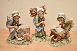 A group of three continental porcelain figurines depicting three old ladies, one on a grind stone,