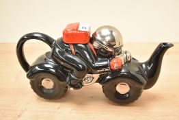 A black and red ceramic novelty tea pot in the form of a motorbike racer, L26cm