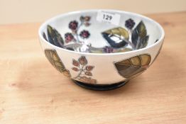 A Moorcroft pottery bowl tube lined in the 'Brambles' pattern and raised on a circular foot, painted