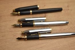 Three Cross cartridge / converter fill fountain pens two in chrome with gold trim and one matt black