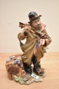 A large Capodimonte porcelain tramp figurine, measuring 30cm tall. Having damage to fingers and