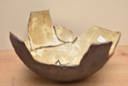 A studio pottery bowl decorated with geometrical patterns on a brown glaze and having impressed mark