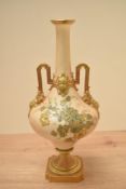 A Royal Worcester porcelain vase having twin handles and floral patterns, green makers mark to base,