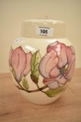 A Moorcroft pottery ginger jar with cover, decorated with floral patterns on a cream ground, painted