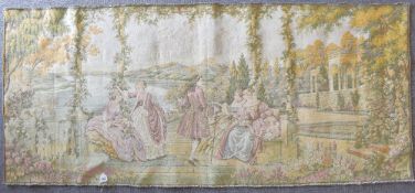 A vintage Abusson style tapestry depicting four ladies and a gentleman lounging in a lush garden