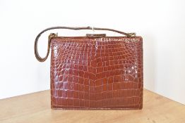 A vintage structured handbag in patent tan crocodile leather, with a structured handle, mirror,