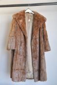A vintage fur coat, 3/4 length, in warm brown coney, measuring 22' from pit to pit.