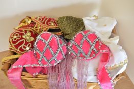 Three belly dancers costumes. A two piece top and skirt in red velvet with gold adornment throughout